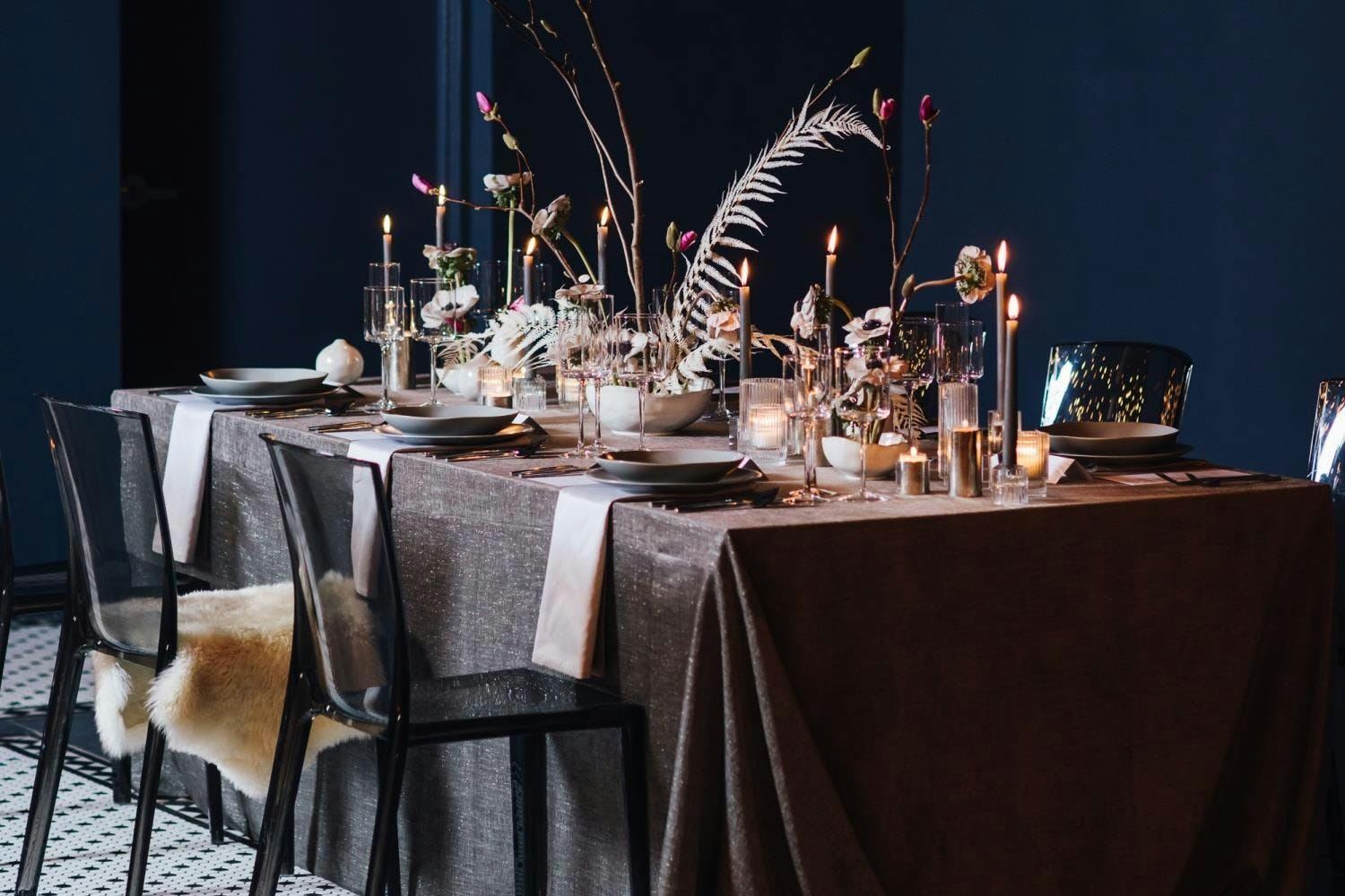 Moody winter tablescape with feather and branch centerpieces | PartySlate