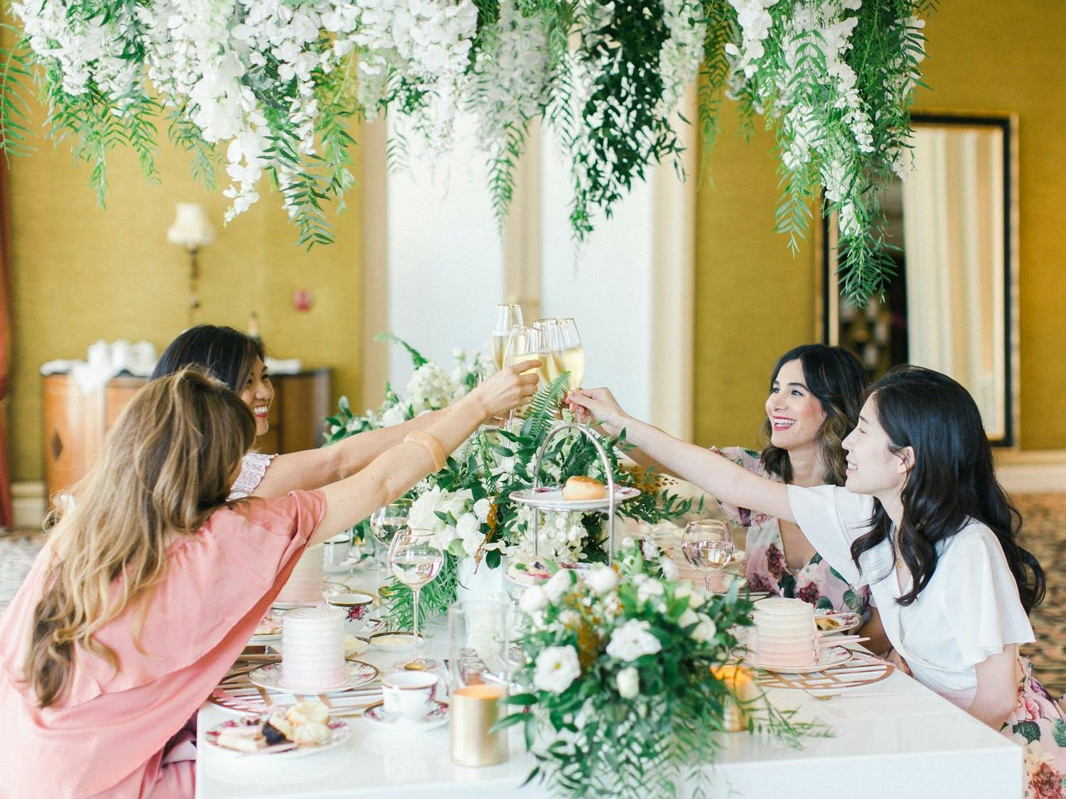 Women gather at table beneath lavish greenery at The Langham Huntington Hotel for product launch event | PartySlate