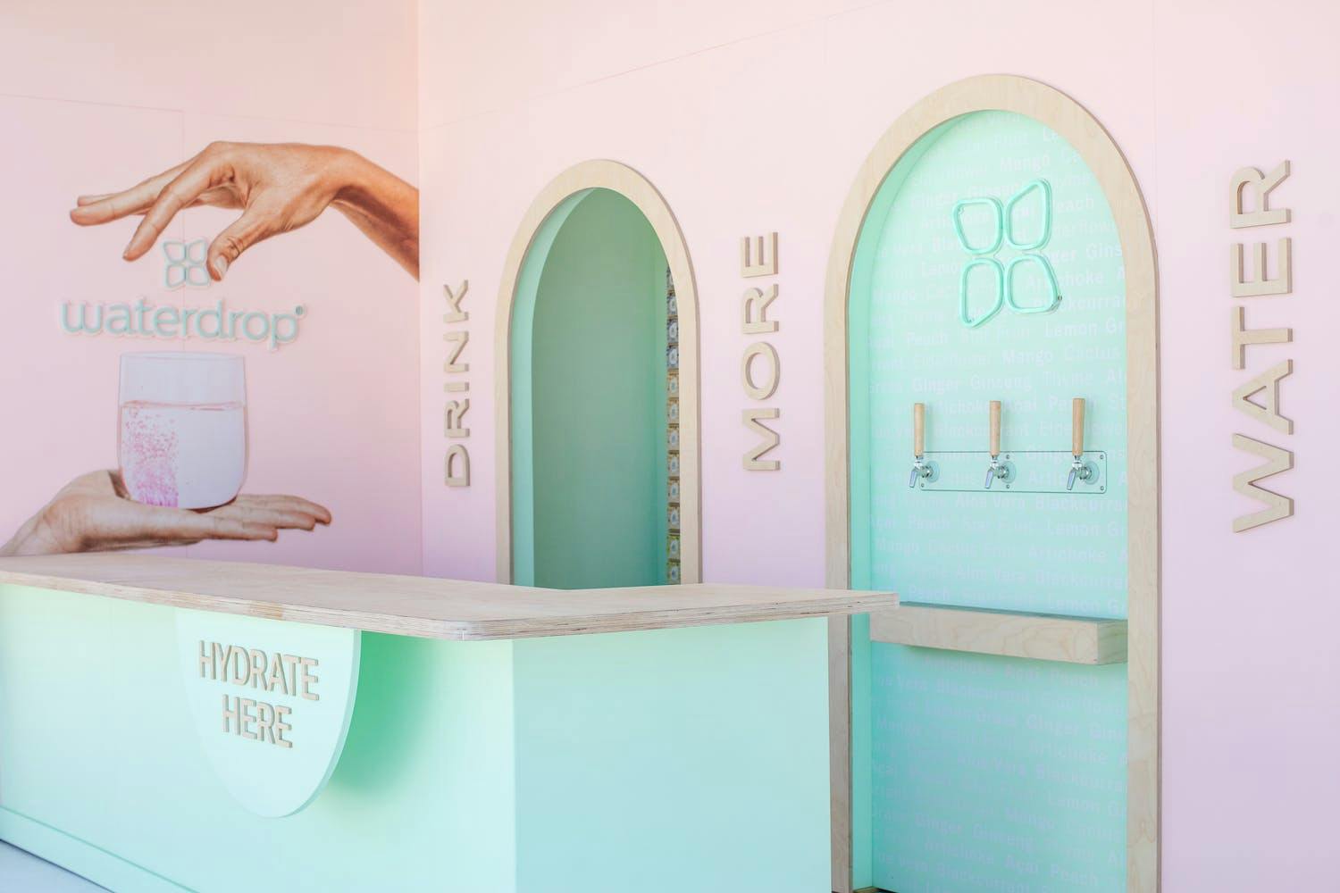An interactive pastel pink and green colored water station at a corporate event | PartySlate
