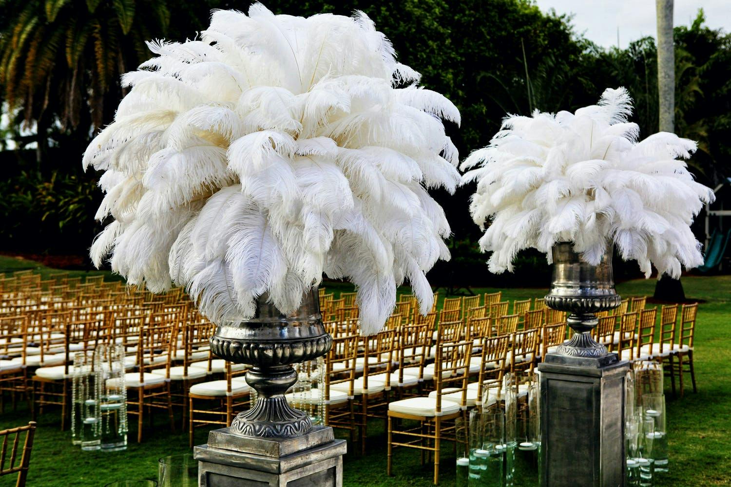 White feather décor at wedding aisle entrance | PartySlate