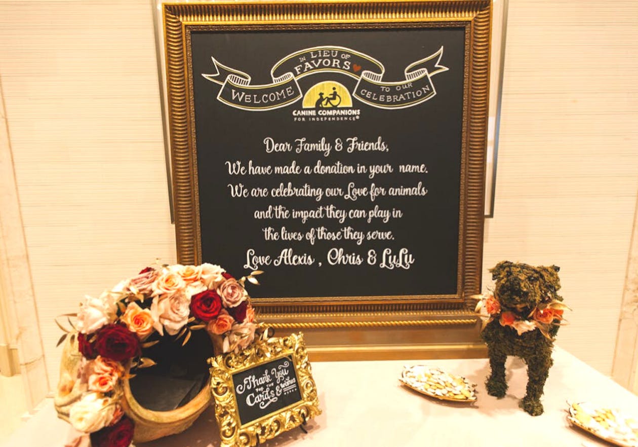 greenery in shape of dog next to sign about wedding party favors | PartySlate
