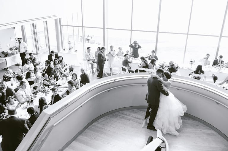 Black and White Photo of Couple at Botanic Gardens in Fort Worth Standing on Atrium Stairs | PartySlate