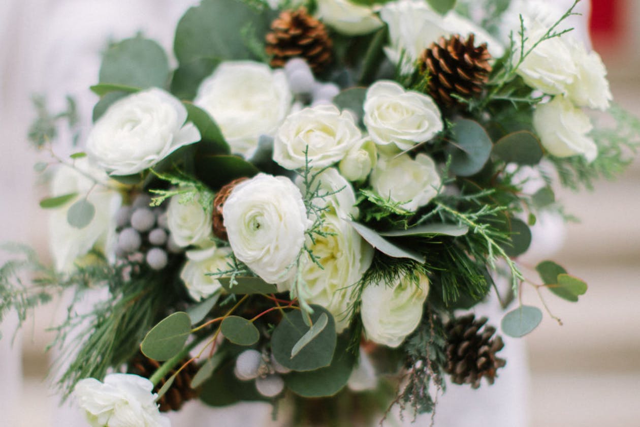 Winter wedding bouquet with pine cones | PartySlate