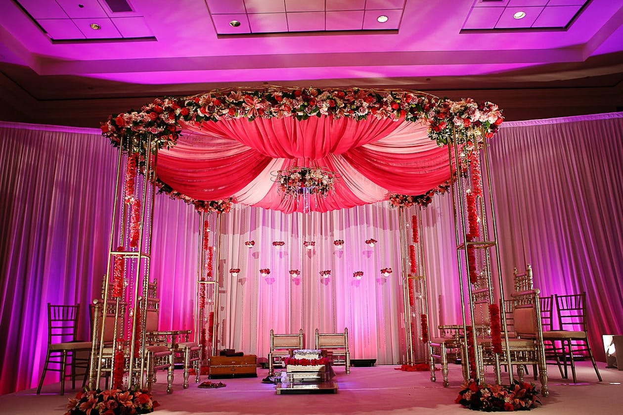 Pink Indian wedding mandap in purple uplit ballroom | PartySlate