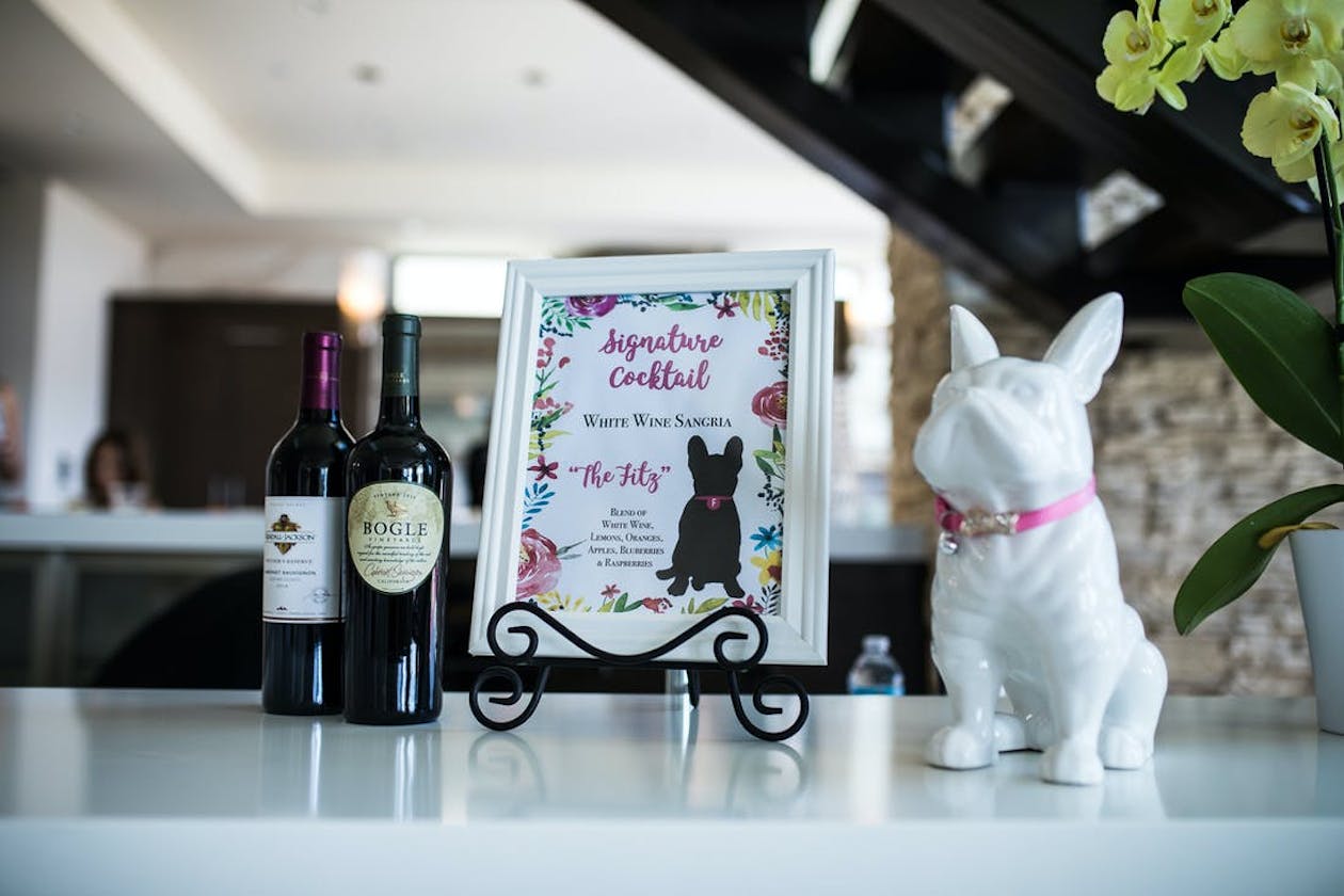 white dog ceramic next to wedding cocktail menu with black down drawing | PartySlate