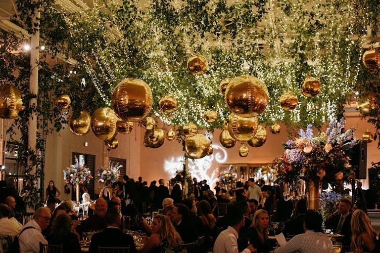 Extravagant Wedding with Greenery and Gold Disco Balls from the Celling Over Dance Floor | PartySlate