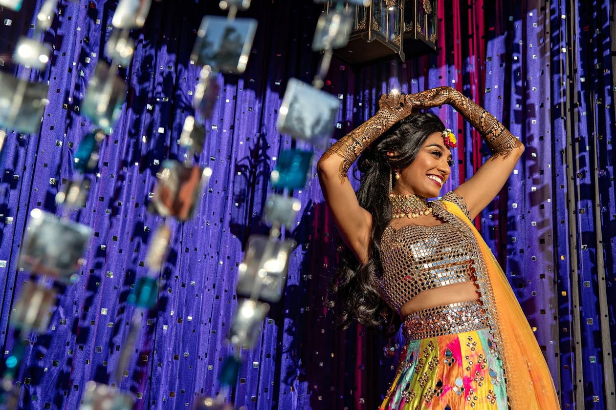 Bride dance against purple backdrop at Indian wedding sangeet | PartySalte