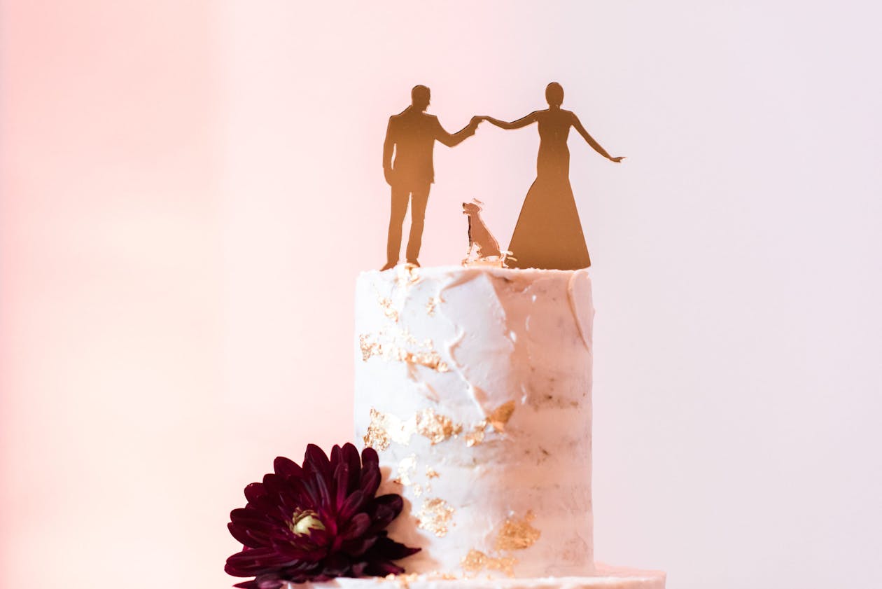 naked wedding cake with gold bride, groom, and dog topper | PartySlate