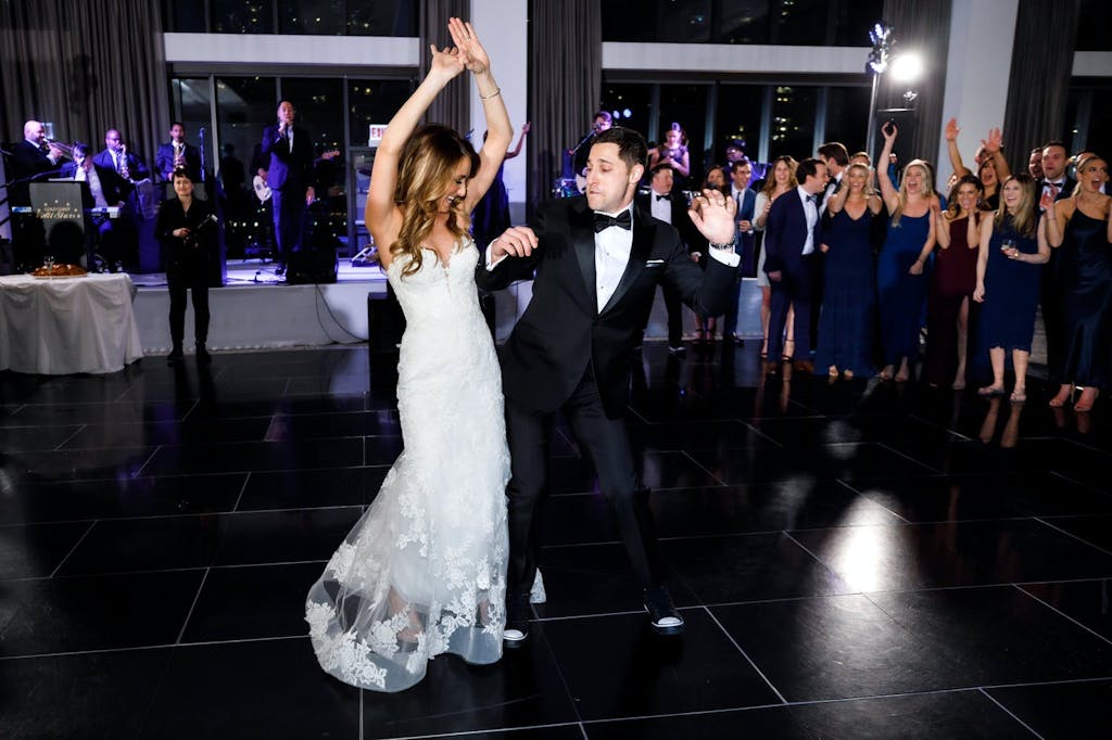 Couple bump hips during first dance at wedding | PartySlate