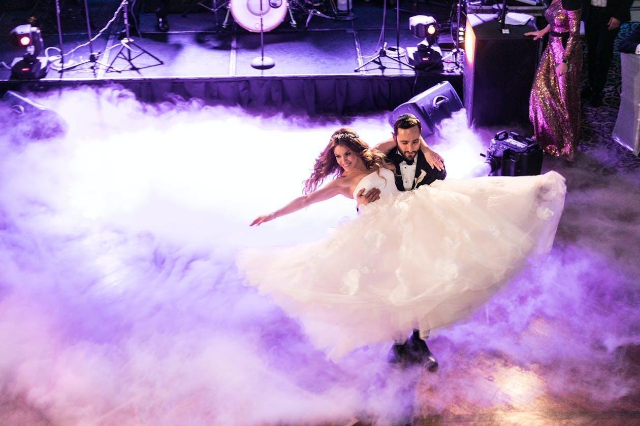 Couple dances through swirling purple fog at wedding | PartySlate