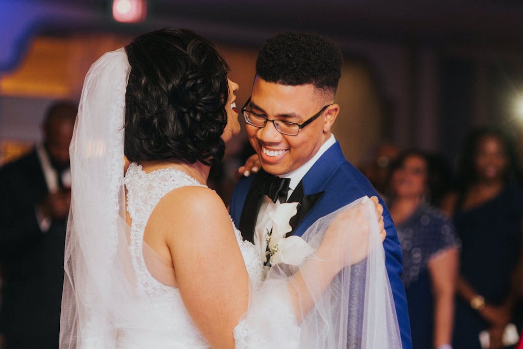 Couple smiles happily during their first dance | PartySlate