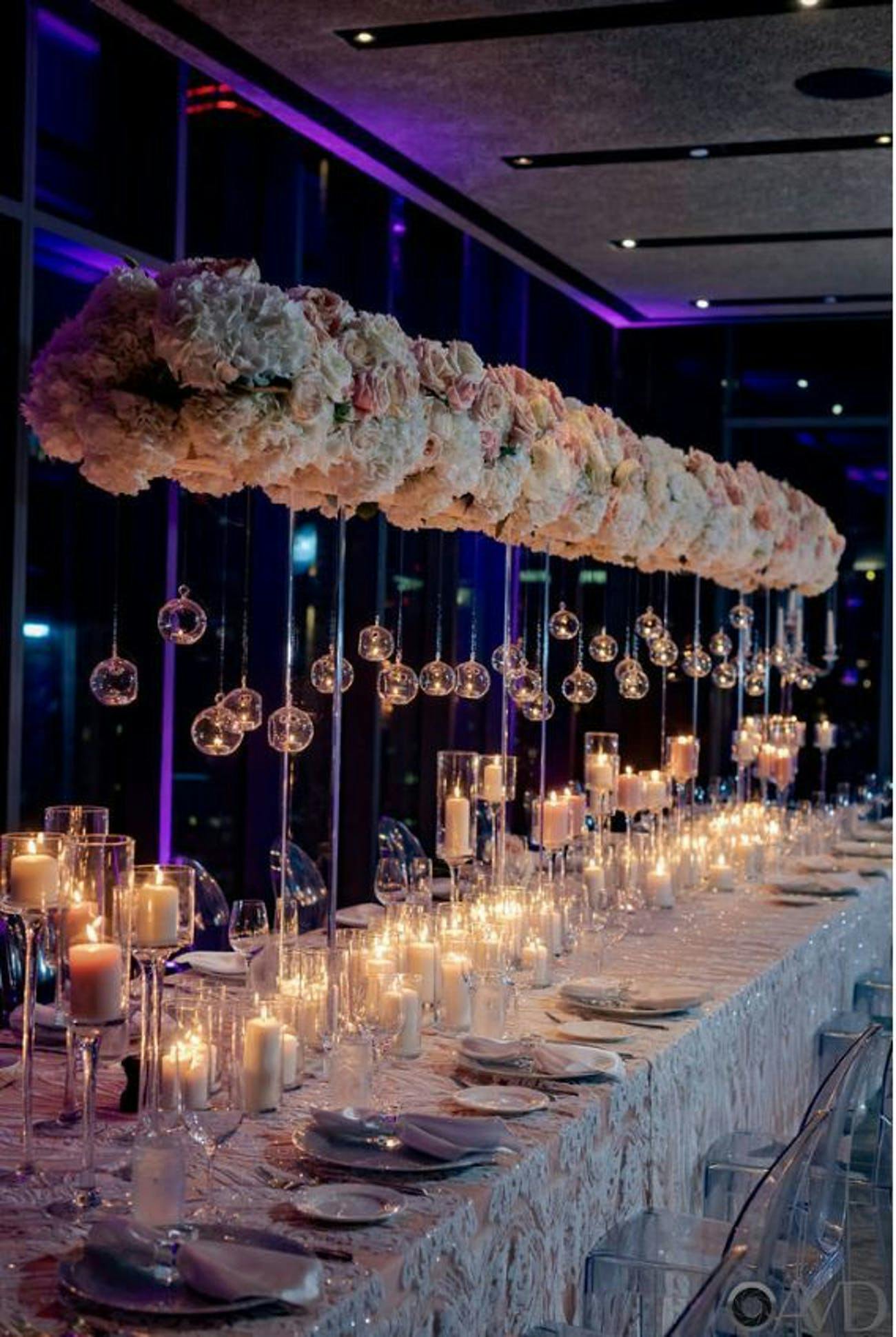 Elevated white and pink floral centerpieces with suspended globed candlelight | PartySlate