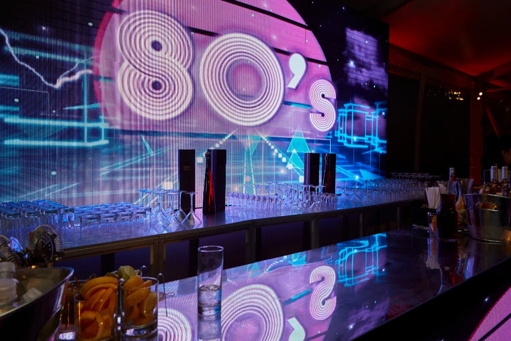 80s Party Theme with pink, blue, and purple neon signage | PartySlate