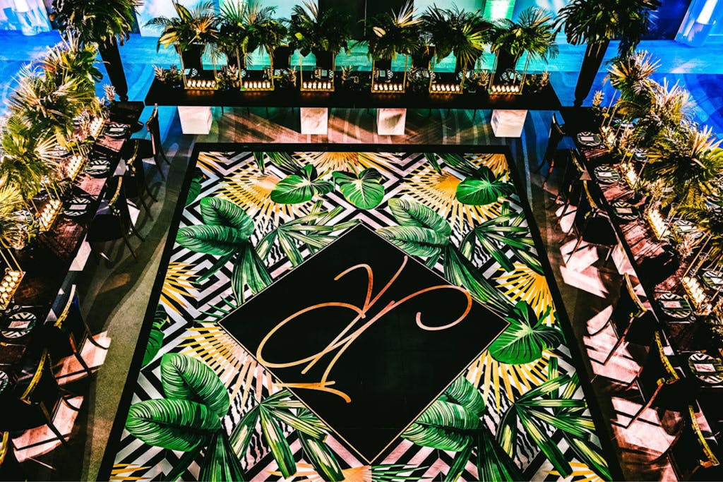 Tropical 40th birthday party with jungle-patterned dance floor in green, gold, and black | PartySlate