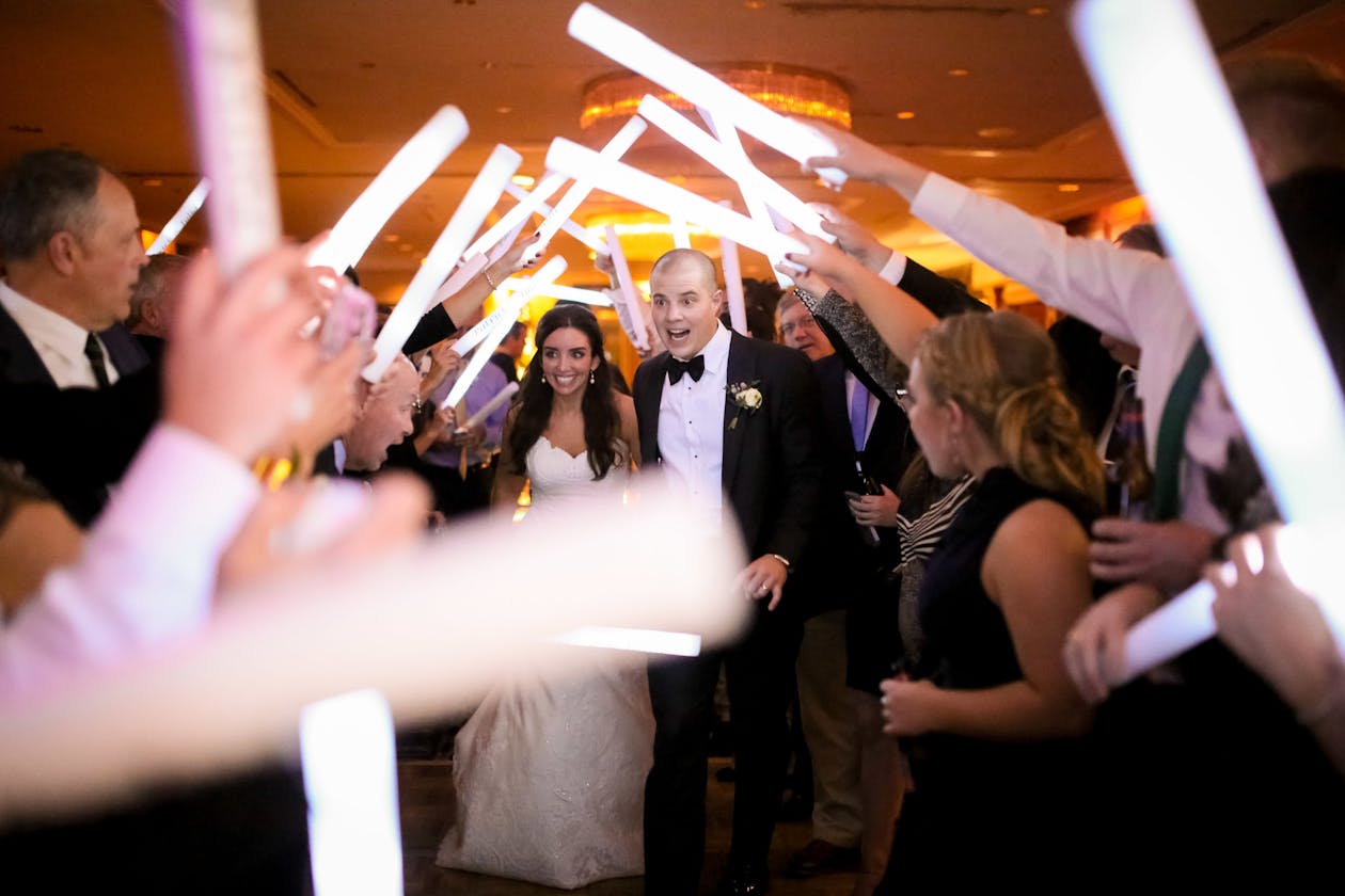 Fairytale Winter Wedding in Chicago Couple Leaving Wedding venue As Guests Wave Glow Sticks | PartySlate