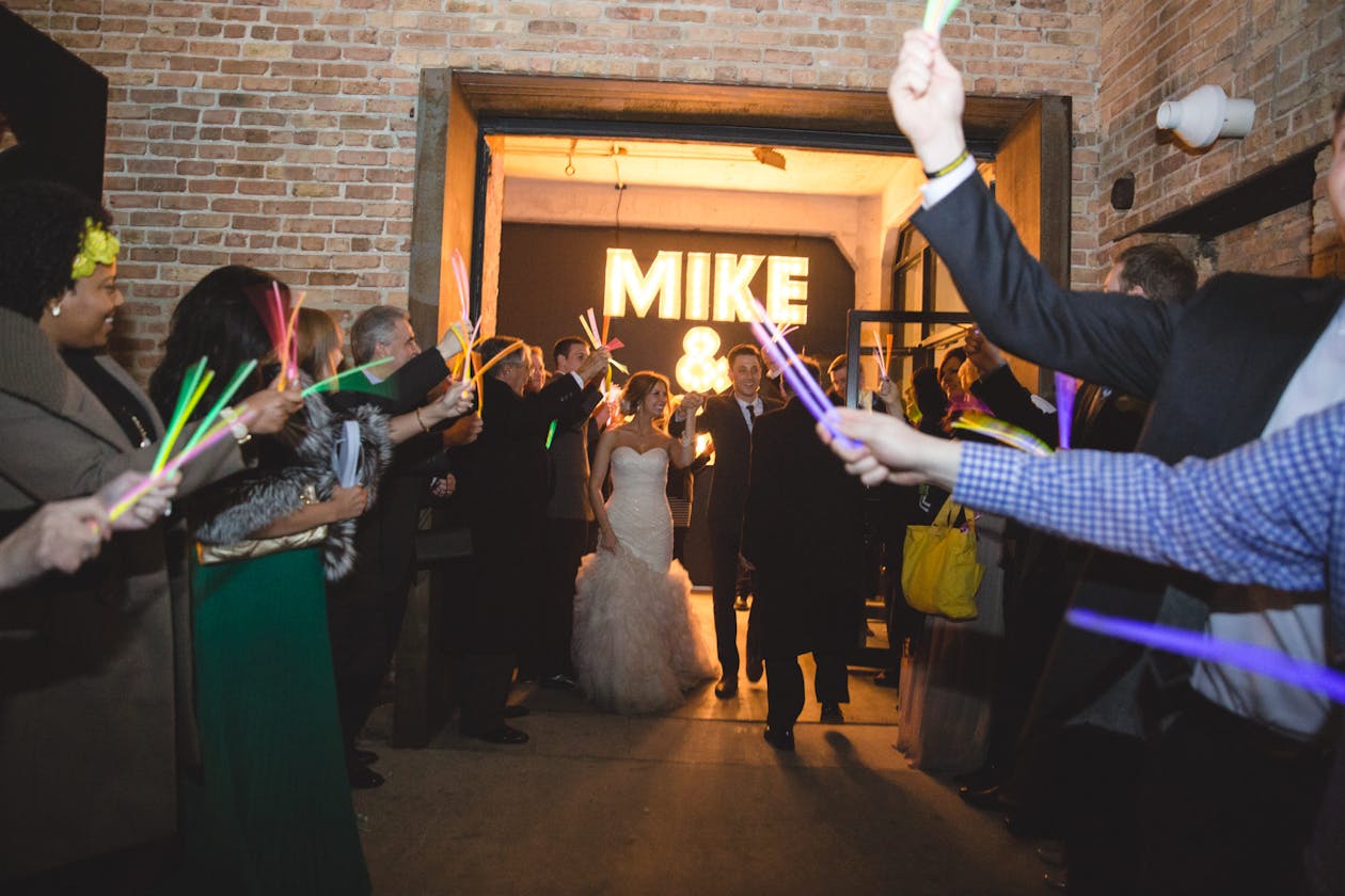Couple Leaving Wedding venue As Guests Wave Glow Sticks | PartySlate