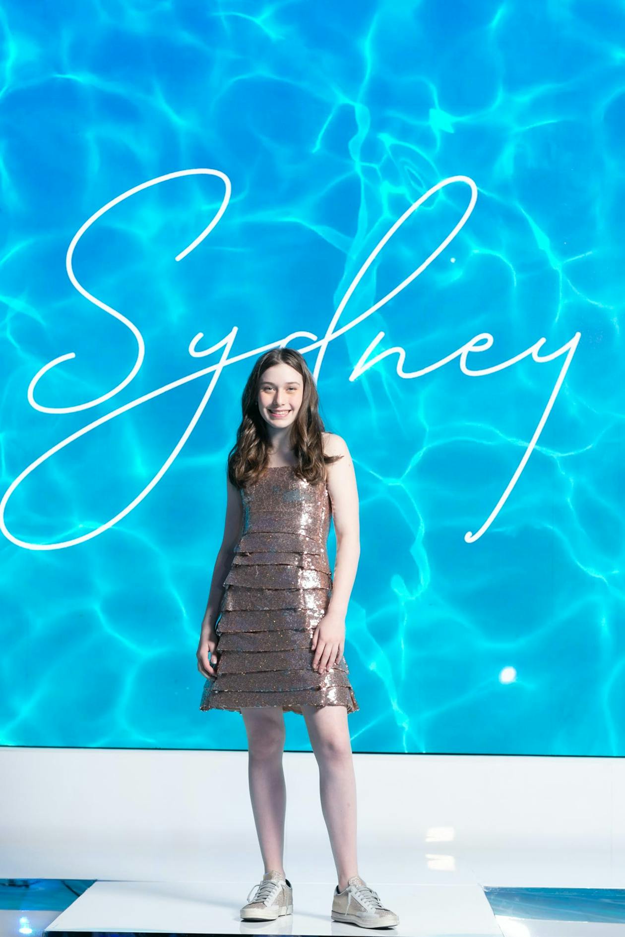 Indoor Underwater Pool Party With Blue Colors Scheme and Pool Party Details and Birthday Girl Standing In Front Of Personalized Name Sign | PartySlate