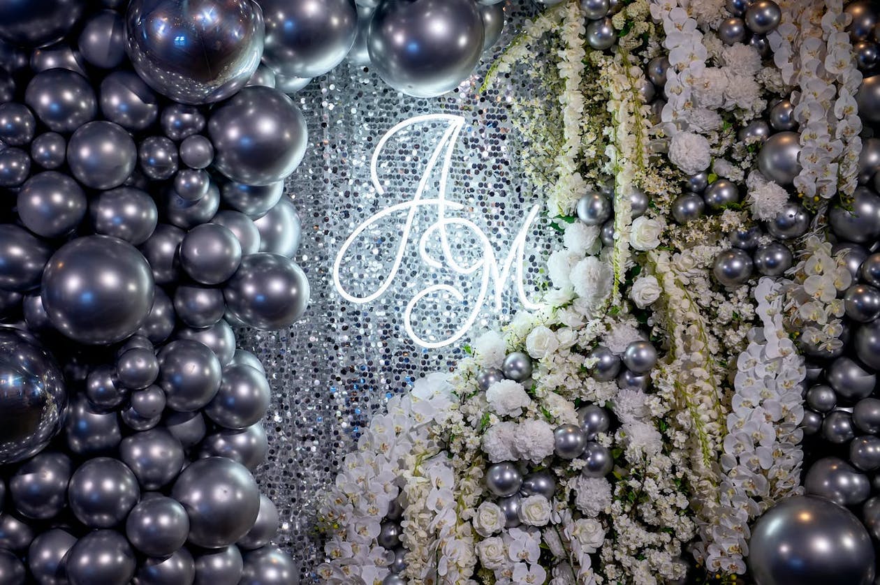 Monogram Quinceanera Sign with Florals and silver balloons | PartySlate