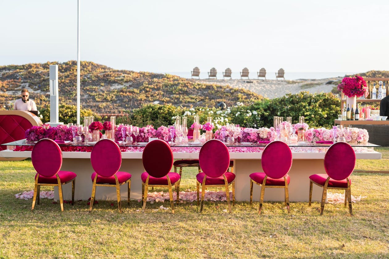 Barbie Themed Pink Party With Hot Pink Decor and Florals on Dining Table with Beach View | PartySlate