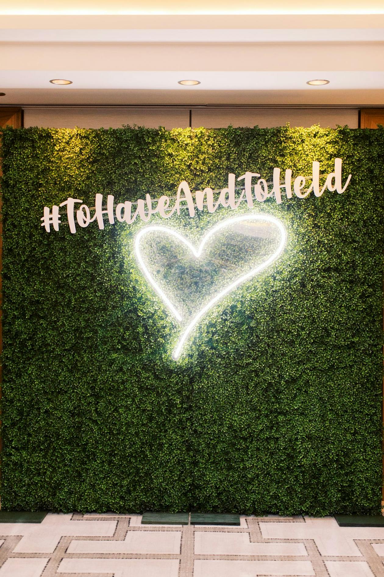 Wedding Hashtag Sign on Wall With Neon Heart Below | PartySlate