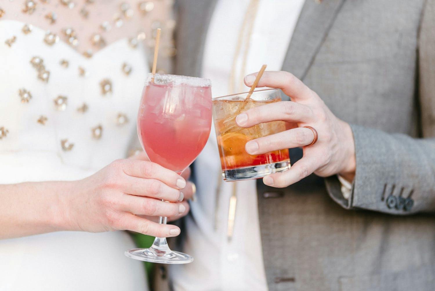 Bride and groom click signature cocktails at desert wedding | PartySlate