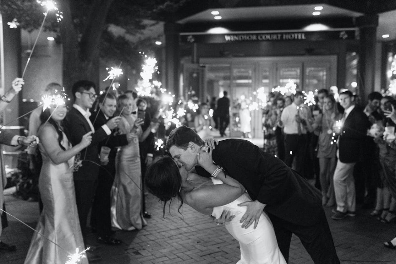 Wedding Exit At Windsor Court Black and White Photo With Sparklers and Couple Kissing | PartySlate