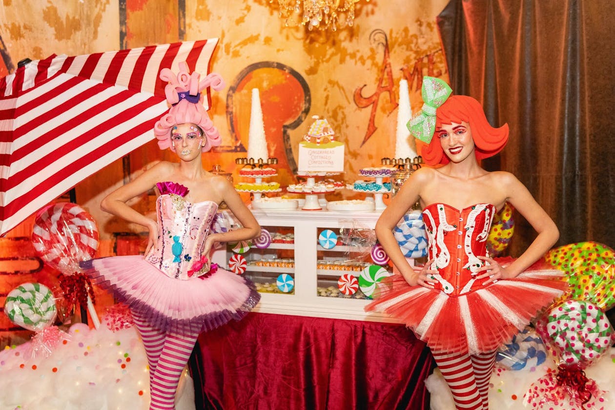 Two ladies in colorful wigs and tutus at Candy Land theme party | PartySlate