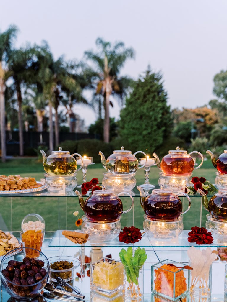 Tea Station At Outdoor Wedding With Clear Glass Tea Pots and Mugs | PartySlate
