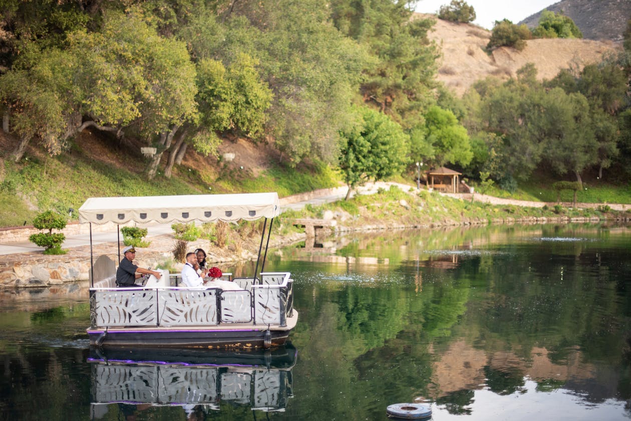 Red Romantic Outdoor Wedding at Los Willows Wedding Estate in Fallbrook, CA With Couple Leaving Venue On A Fairy Boat | PartySlate