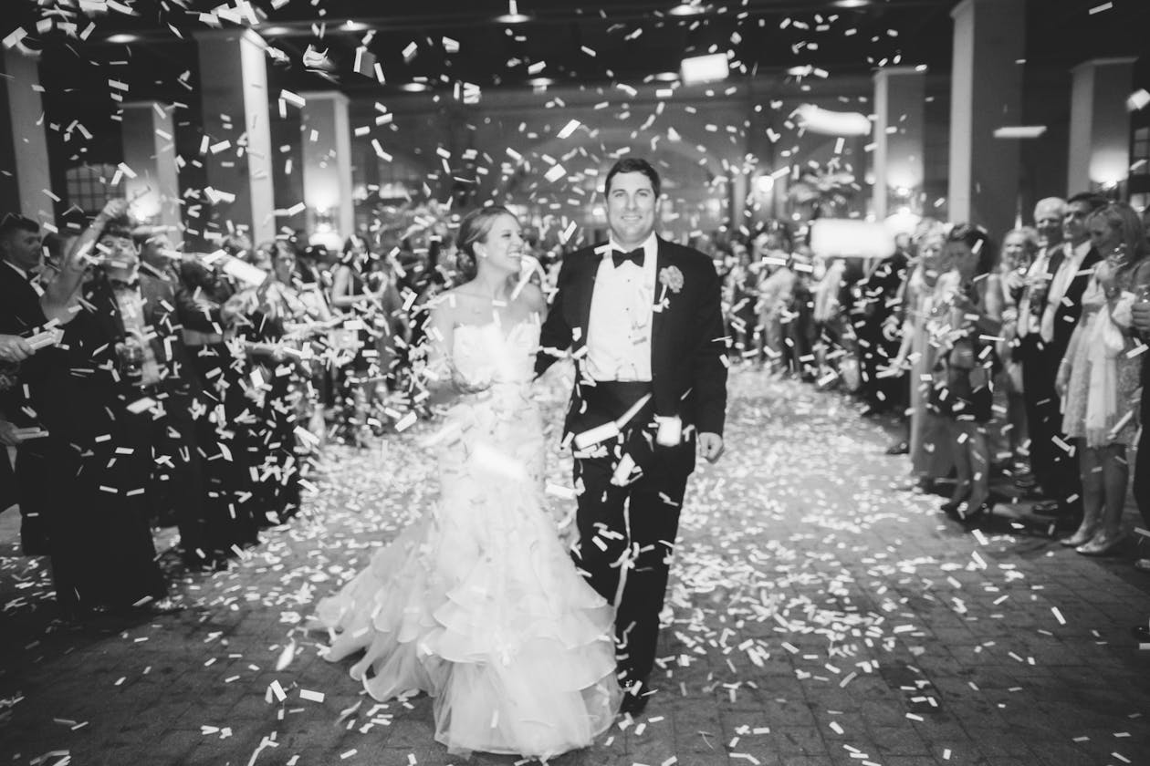 Vibrant Wedding in Galveston, TX With Black and White Photo of Couple Exiting Wedding In Confetti | PartySlate