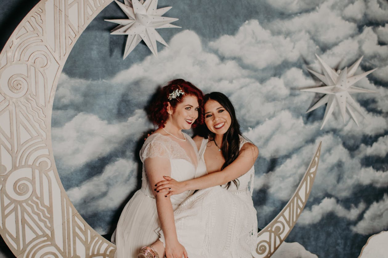couple posing and hugging on moon backdrop at wedding | PartySlate