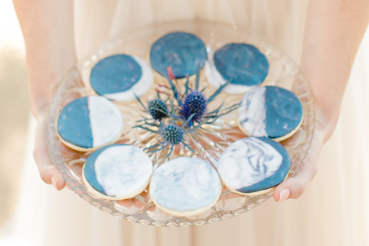 moon shaped and decorated cookies in blue and white on a plate | PartySlate