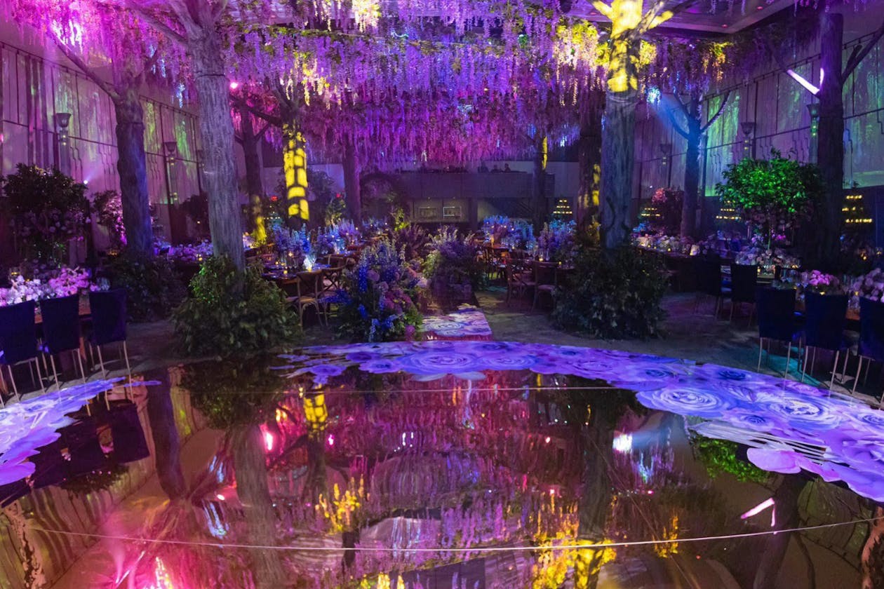 Enchanted forest whimsical wedding with pink and purple floral ceiling and dance floor | PartySlate