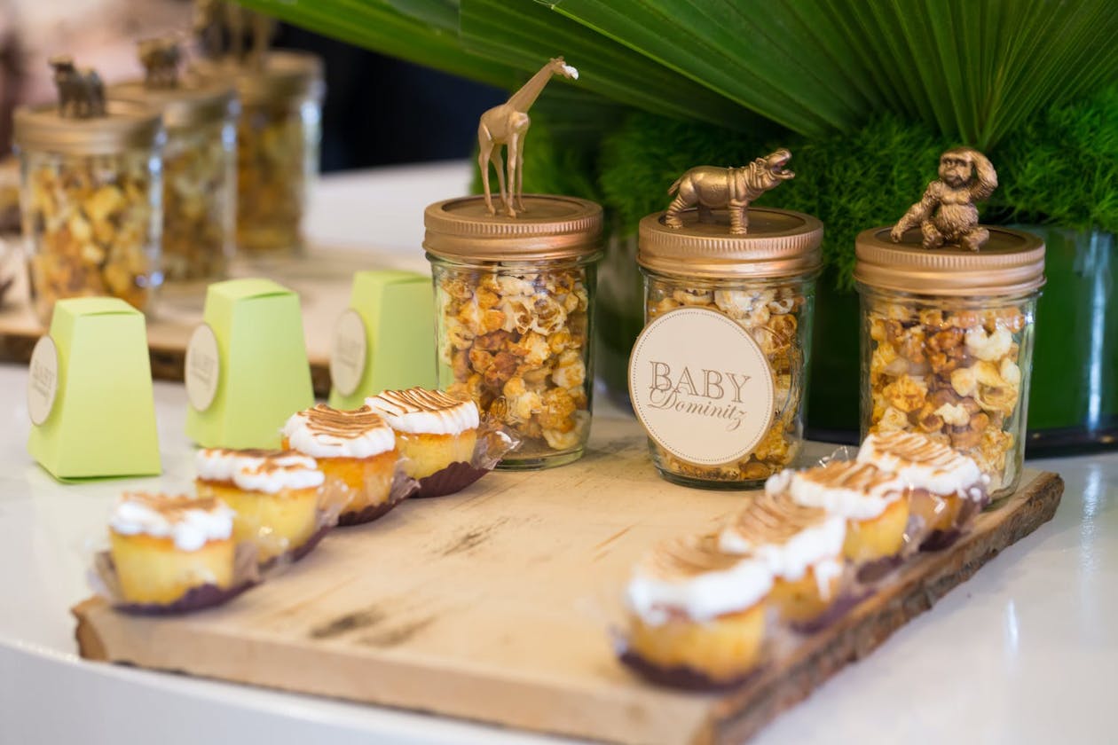 Candied popcorn jars topped with gold-dipped animal figurines | PartySlate