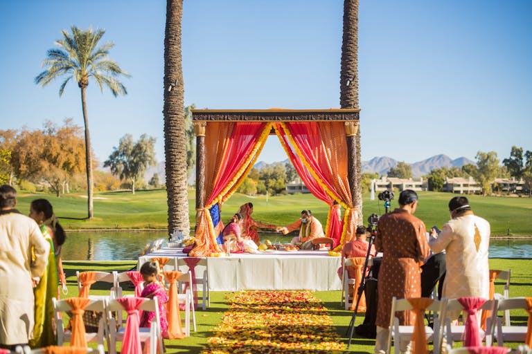 Vibrant Southeast Asian Wedding at Hyatt Regency Scottsdale Resort & Spa at Gainey Ranch in Scottsdale, Arizona With Colorful Alter and Florals Lining Aisle | PartySlate