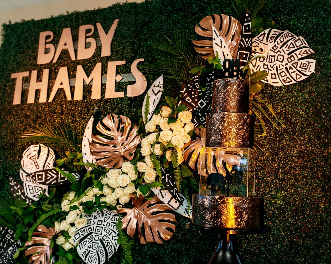 Golden baby shower cake against safari theme backdrop | PartySlate