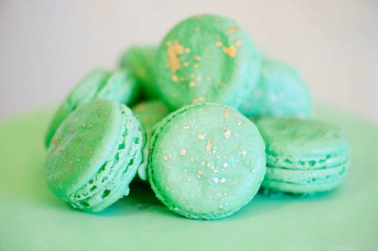 Mint green macaroons with gold flakes | PartySlate