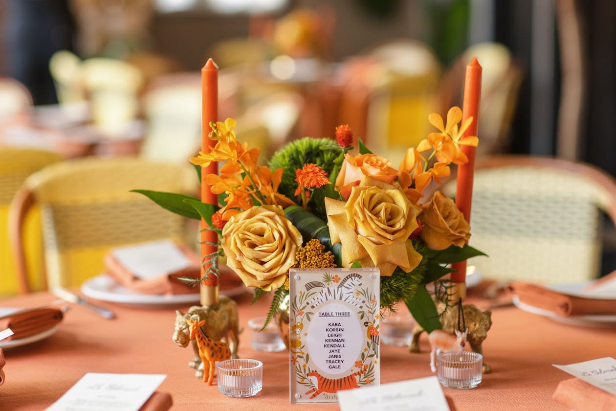 jungle theme baby shower centerpiece with orange candles and gold roses | PartySlate