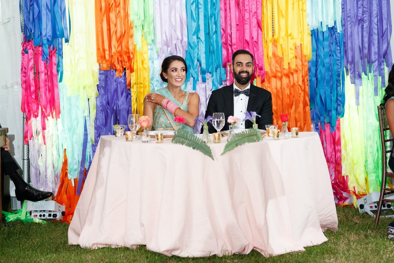 Intimate backyard wedding with rainbow tassel backdrop | PartySlate