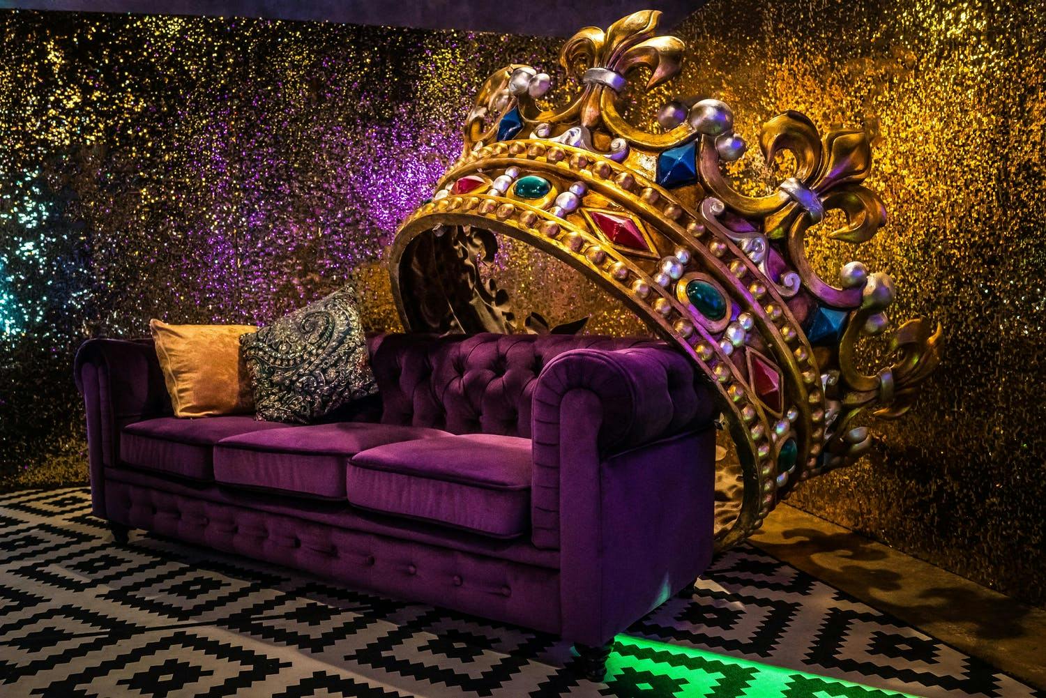 Purple couch with giant crown for Mardi gras party photo op | PartySlate