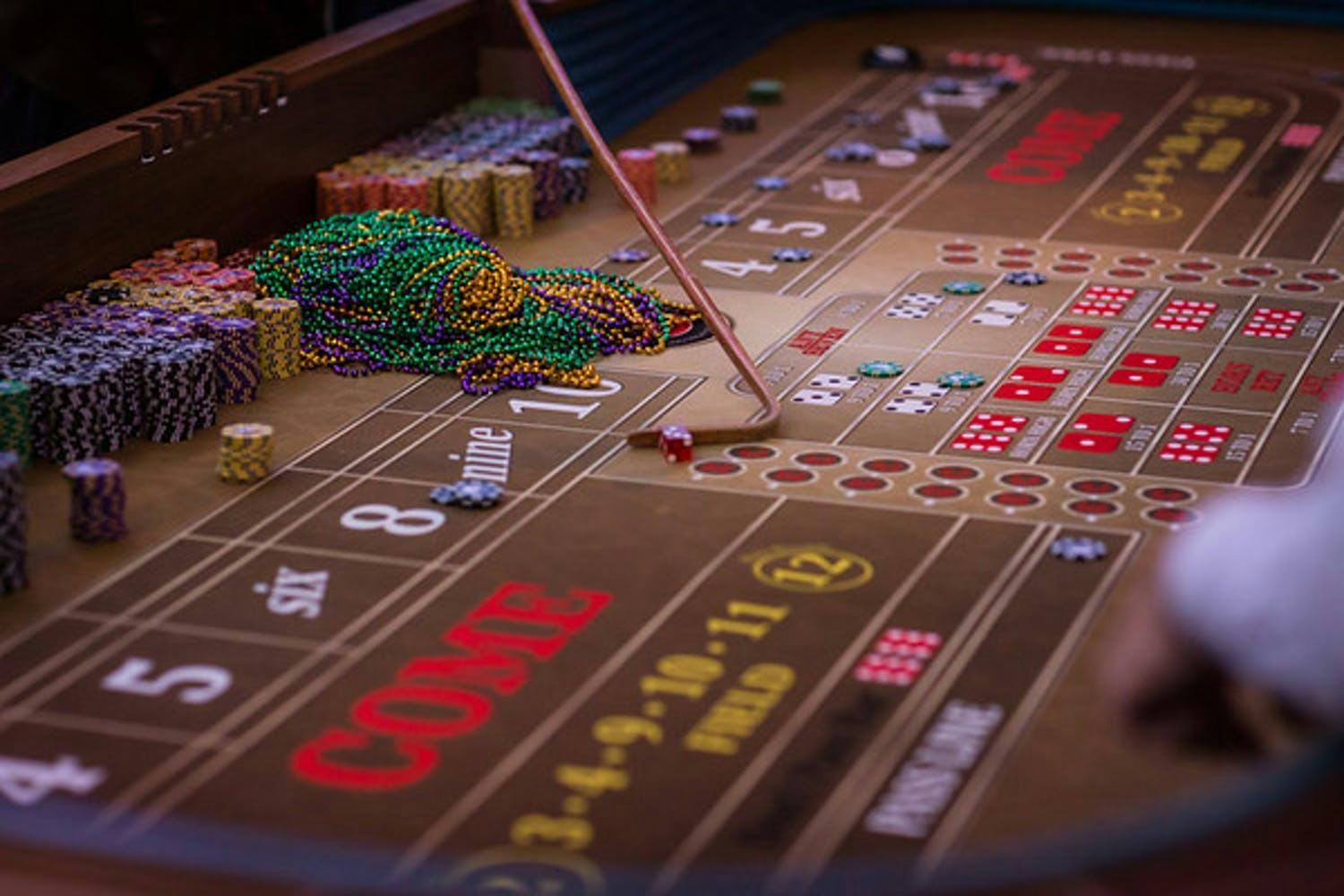 Mardi Gras beads lay on casino table at Mardi Gras themed corporate event | PartySlate
