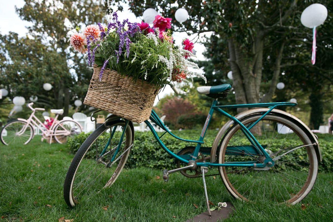 Teal bicycle with basket filled with flowers for vintage wedding theme | PartySlate