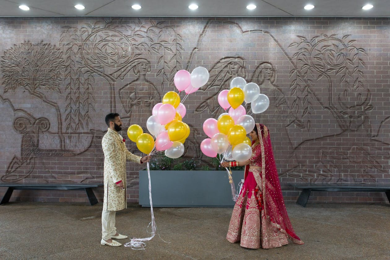 Hindu wedding first look with yellow and light pink ballons | PartySlate