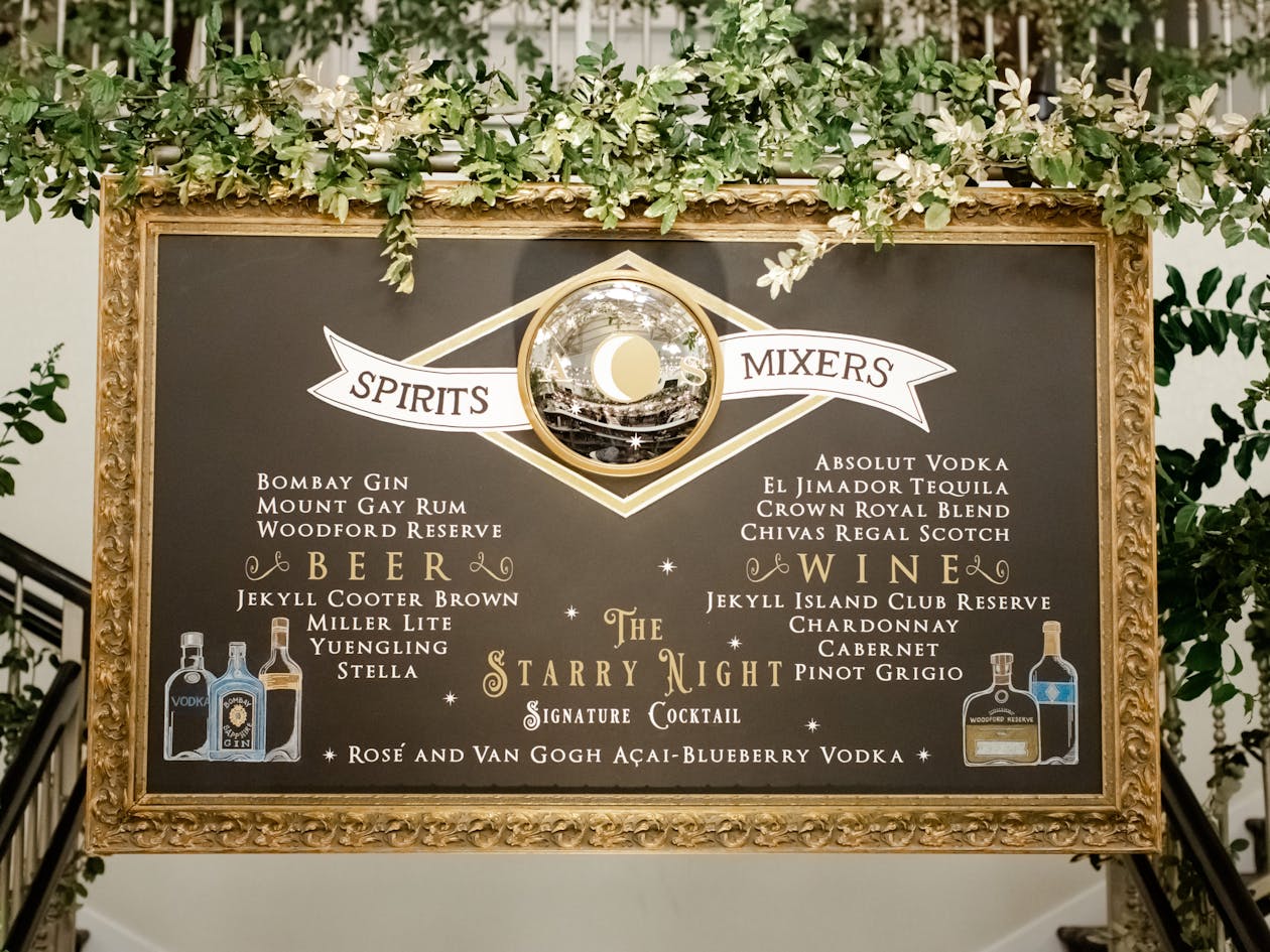 celestial themed food and drink menu in gold frame with greenery around it | PartySlate