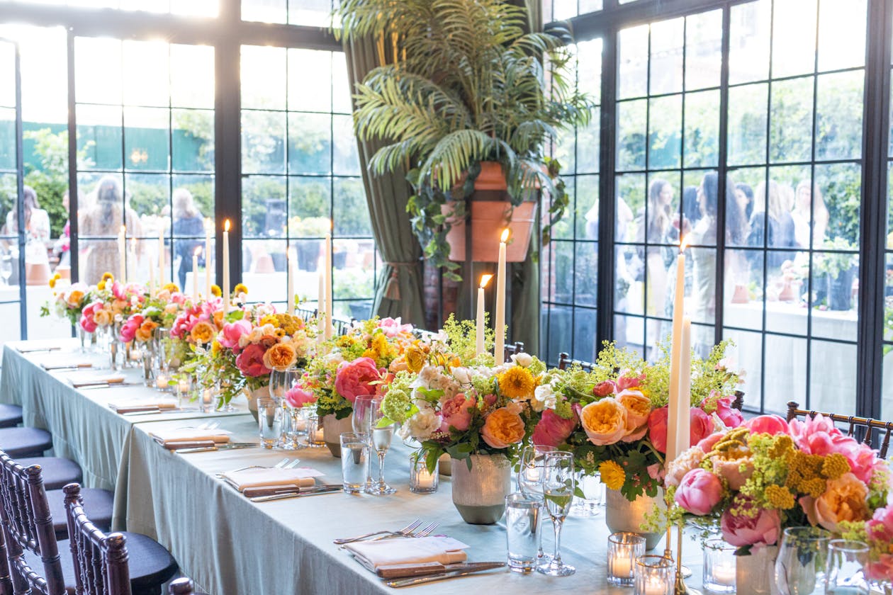 Spring Centerpieces on Table With Tall Candles In Between | PartySlate