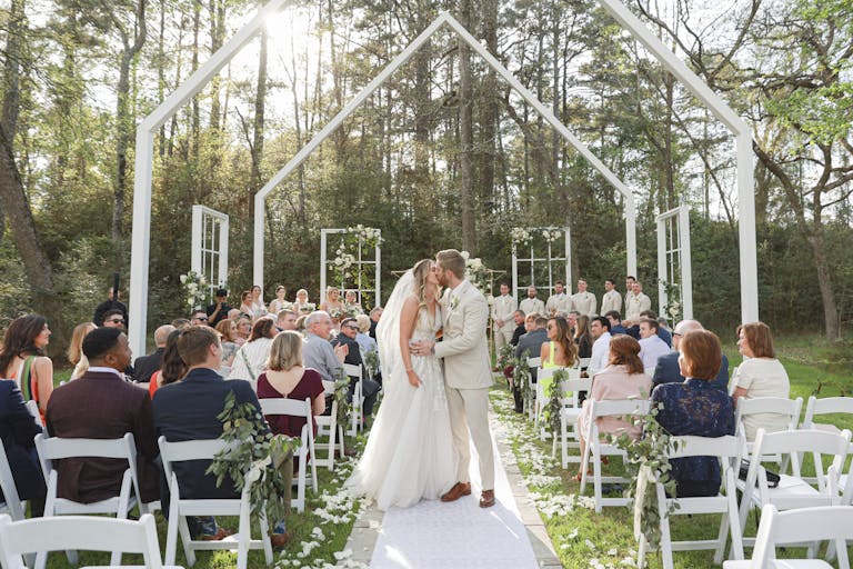 Stunning Outdoor Wedding WIth Couple Walking Down Aisle and Guests Seated | PartySlate