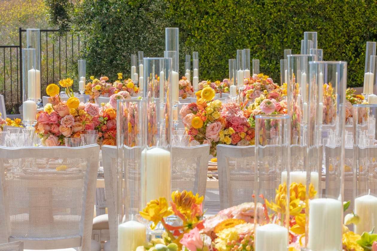 Colorful Pink Yellow and Orange Spring Wedding Centerpieces With Candles in Glass Holders | PartySlate