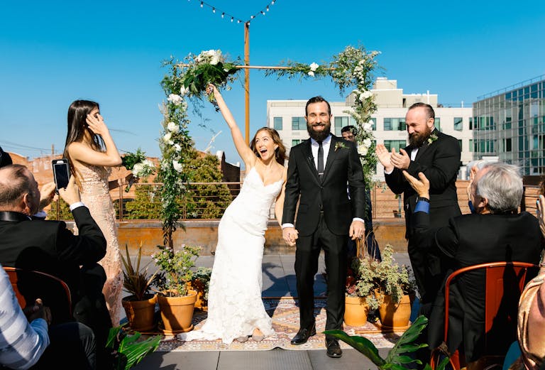 Simple Outdoor Wedding With Couple Standing At Alter And Bride Throwing Bouquet In The Air | PartySlate