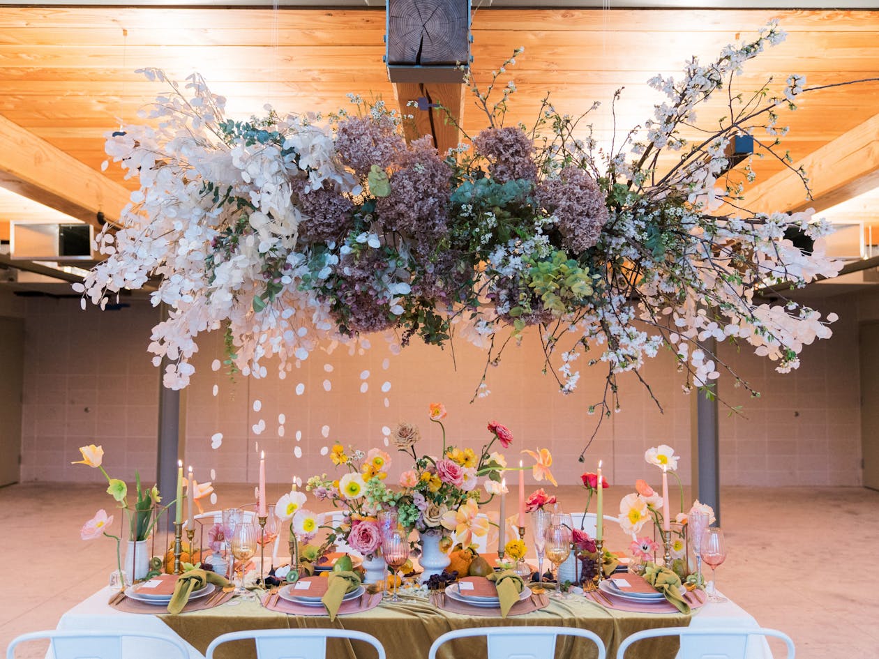 Colorful Spring Wedding centerpiece With Florals on Table and Hanging Above | PartySlate