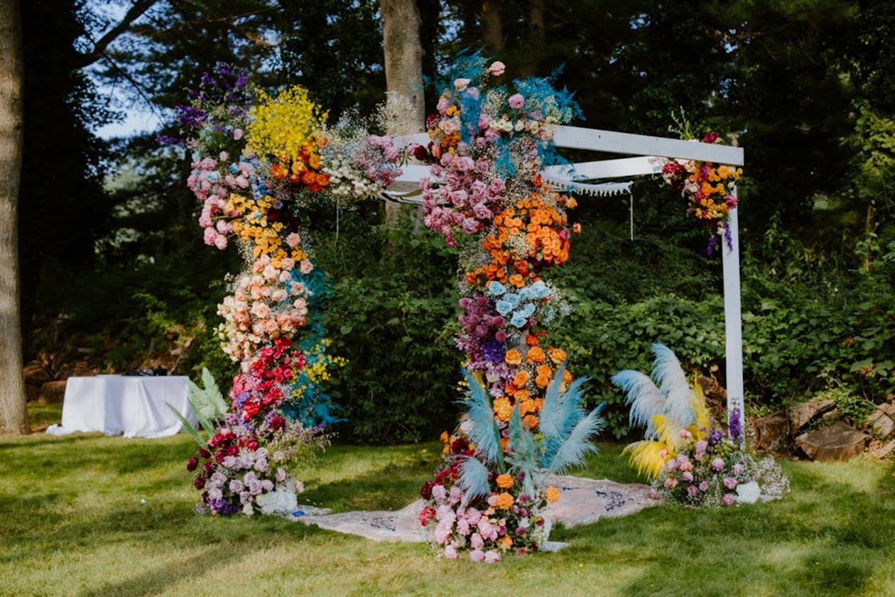 Whimsical wedding chuppah with tie-dyed flowers | PartySlate